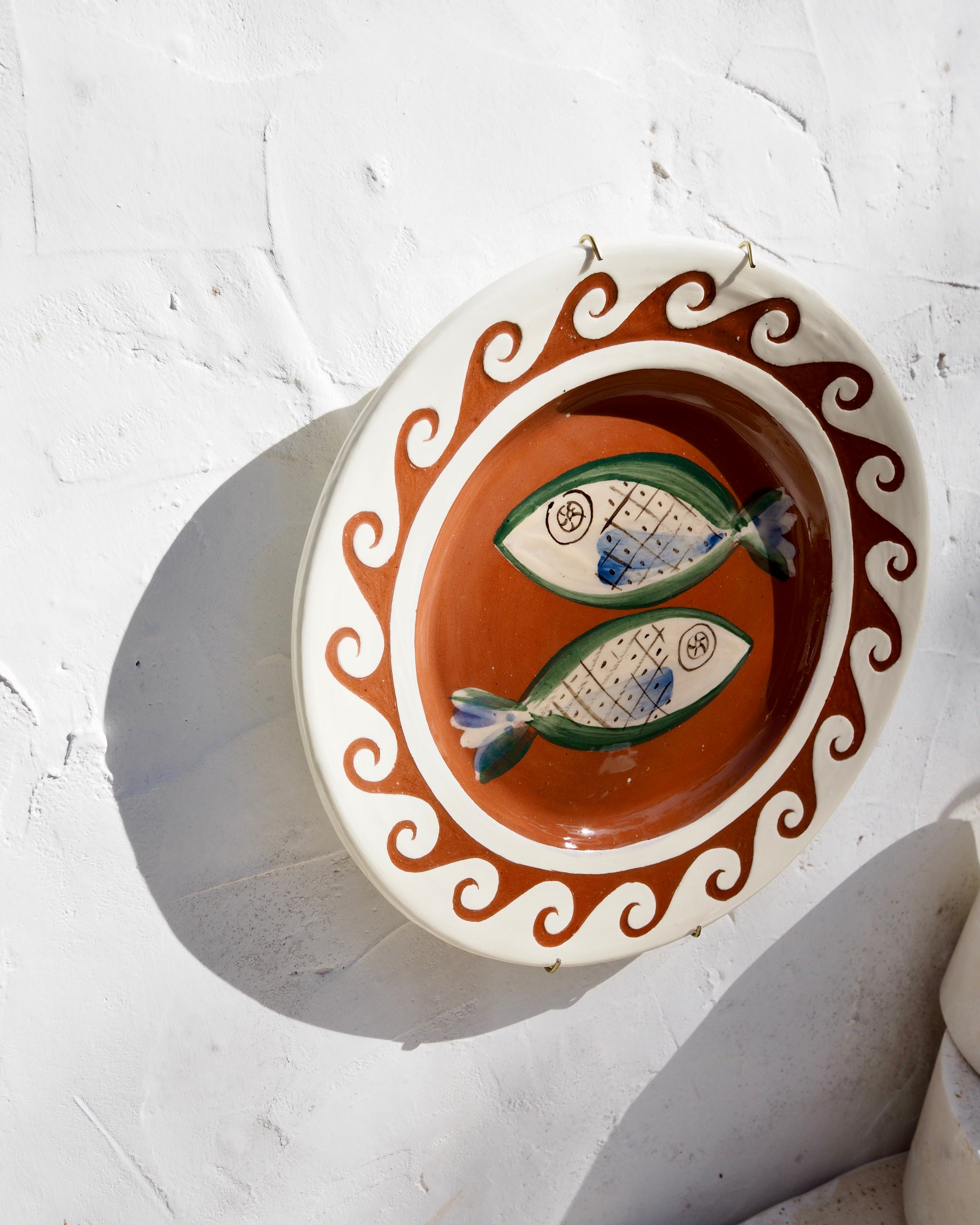 Plate with carved sgraffito wave border and fish design