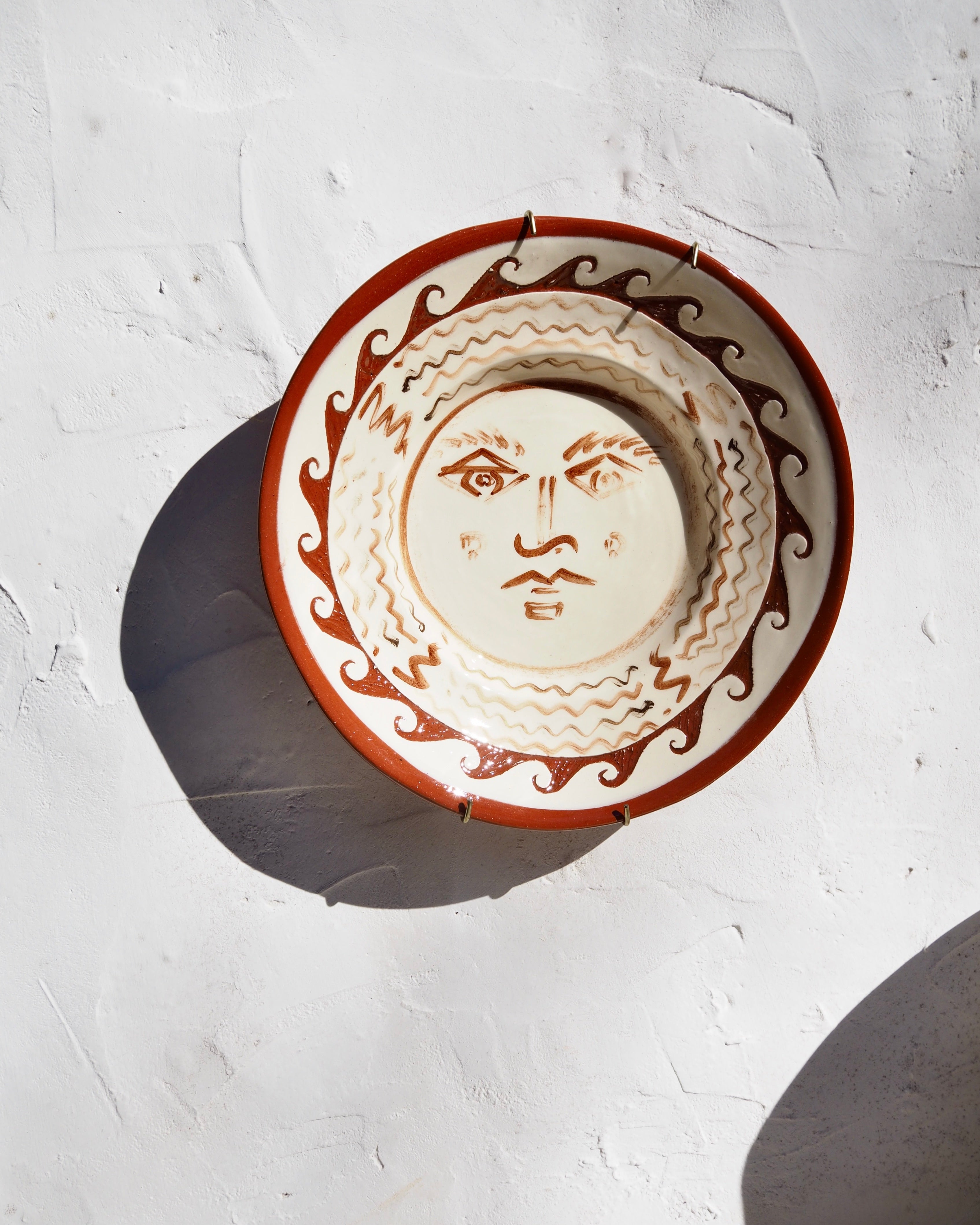 Puglia Plate - Hand painted Il sole face with carved border detail and  brass wall hook