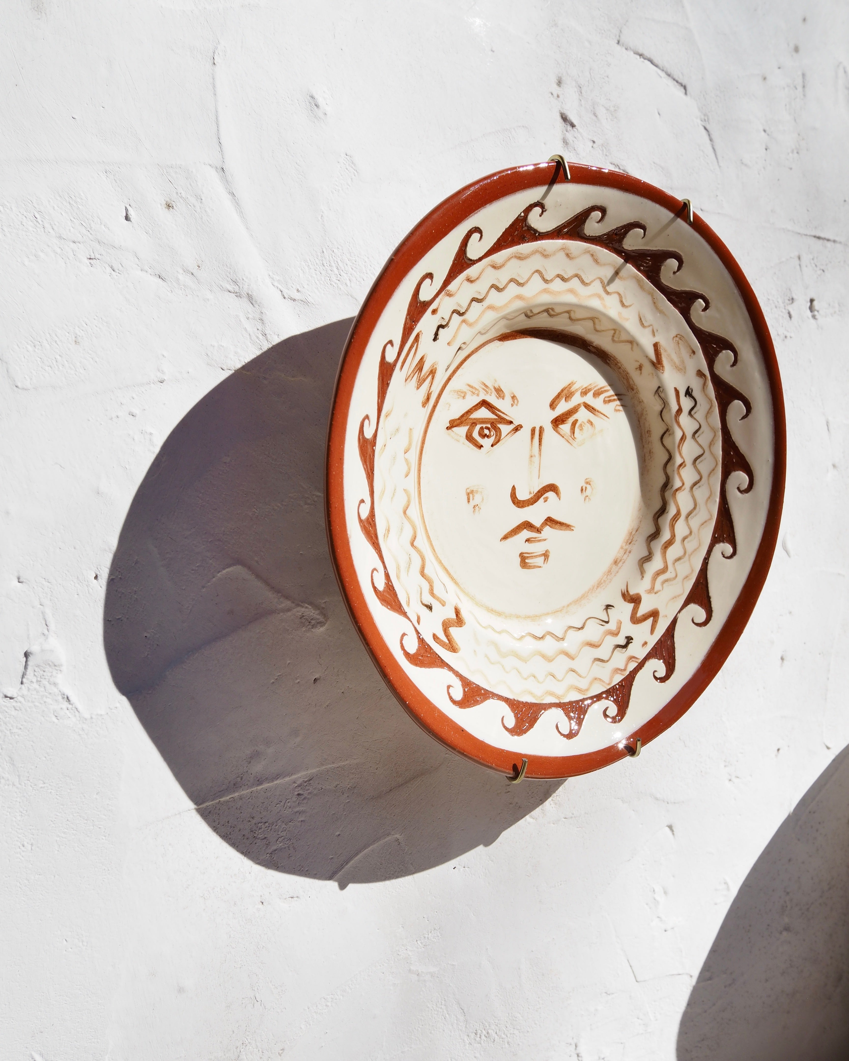 Puglia Plate - Hand painted Il sole face with carved border detail and  brass wall hook